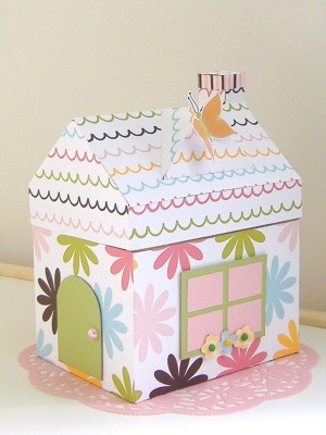 A paper maché house with roof.