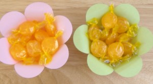 Papel de colores pastel tazón en forma de flor con el caramelo