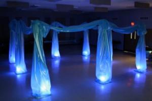 Dance floor with blue lights and draped material forming a canopy over the floor lights.