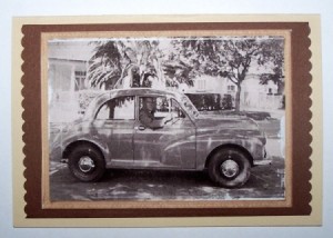 A card with a black and white photo of a man in a car.