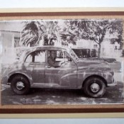 A card with a black and white photo of a man in a car.