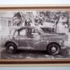 A card with a black and white photo of a man in a car.