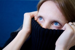 Photo of woman covering her mouth with her turtle nick.