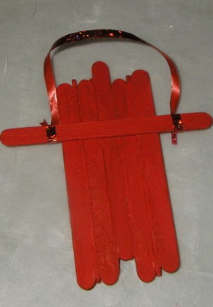 red painted sled with cross member and ribbon pull tied on 