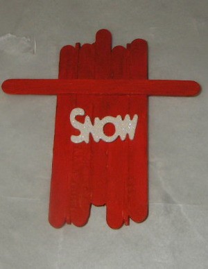 top down view of sled with white letters spelling out snow affixed to top side 