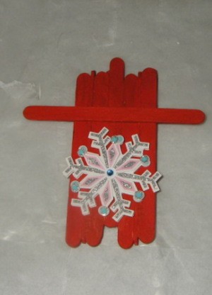 red painted sled with snowflake decoration affixed to top side