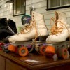 Two pair of roller skates on table at a garage sale.