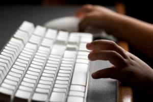 Setting Up Parental Controls on a PC, Childs hands on a computer keyboard.