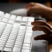Setting Up Parental Controls on a PC, Childs hands on a computer keyboard.