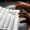 Setting Up Parental Controls on a PC, Childs hands on a computer keyboard.