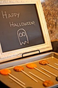 Halloween Lollipop Cookies on Cookie sheet, Happy Halloween writen ona blackboard in the backround.
