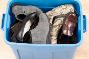 Pile of shoes in blue storage container.