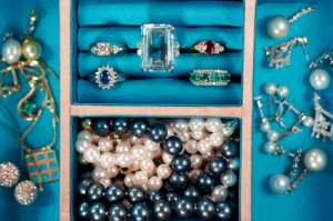 A jewelry box with rings, necklaces and other pieces of jewelry.