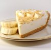 A slice of banana cream pie on a plate with slices of fresh banana.