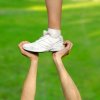 Upclose photo of a cheerleaders foot being held up by another person.