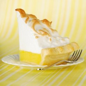 Slice of lemon meringue pie on a plate.
