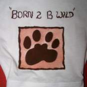 A baby's onsie with a fabric paint design of a paw and the words 