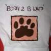 A baby's onsie with a fabric paint design of a paw and the words 
