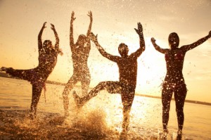 People playing on the beach at sunset.