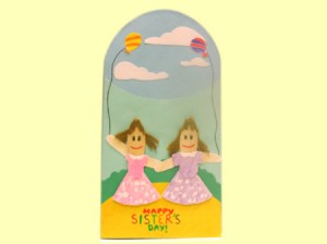 Finished sister card, two popsicle stick girls on a blue background with clouds