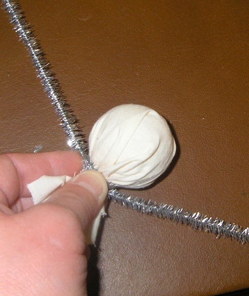 Silver pipecleaner tied around fabric