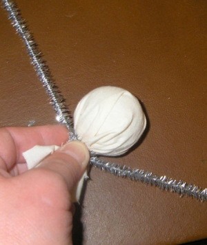 Silver pipecleaner tied around fabric