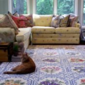 Cat lying on a throw rug in the livingroom.