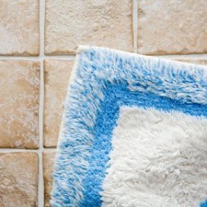 A blue and white rug on a tile floor.