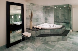 A marble spa tub and floor in a beautiful bathroom.