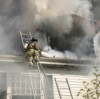 A firefighter in the smoke from a house fire.