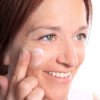 Woman applying wrinkle cream to her face.