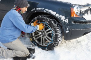 Man Putting Chains on His Car in the Snow