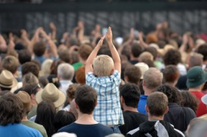 Child Clapping in Crowd at Festival