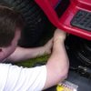 Man tinkering with a riding mower.