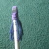 A pencil topper with a funny face and hair.