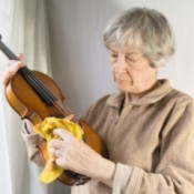 A woman dusting her violin.