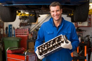 Finding an Honest Mechanic, Mechanic Holding up Car Part in Front of Car