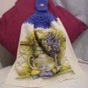 A kitchen towel with blue yarn crocheted on the top.
