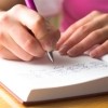 A woman writing in a diary.