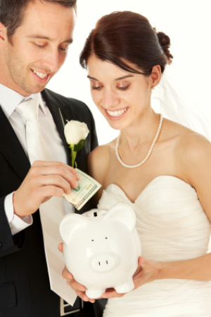 Bride and Groom Putting Money in Piggy Bank