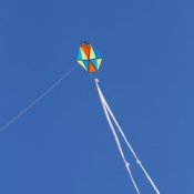 Homemade kite with long double tail against the sky.