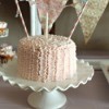 small pink cake with one candle and bunting strung across