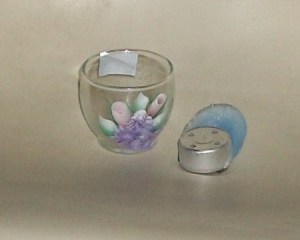 Empty candle holder and tealight with spilled was that has been removed from it