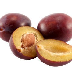 Two whole plums and one cut in half showings it's pit.