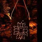 Tin can lantern illuminated with a candle.