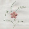 Floral needlework on white fabric.