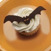 A bat decoration on top of a cupcake.