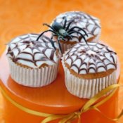 Cupcakes with spiderweb designs on top.