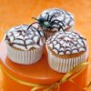 Cupcakes with spiderweb designs on top.