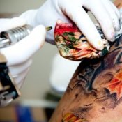 A tattoo artist working on a tattoo.